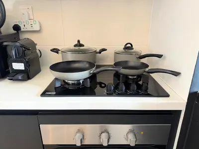 two pots and pans sitting on top of a stove at Wonderful Stay At Zaya Hameni - Best Amenities - Unique in JVC - Brand New Luxury Apartments in Dubai