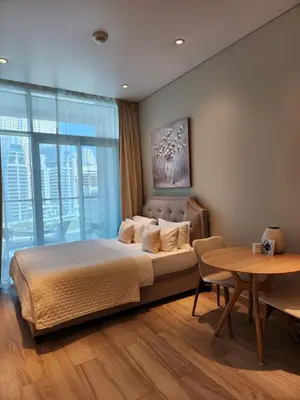 a bedroom with a large bed and a table at STUDIO ONE Stunning Marina View - TIE in Dubai