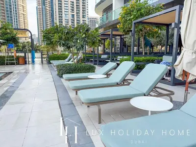 a row of blue lounge chairs and tables on a patio at LUX The Grande Signature Skyline Suite 2 in Dubai
