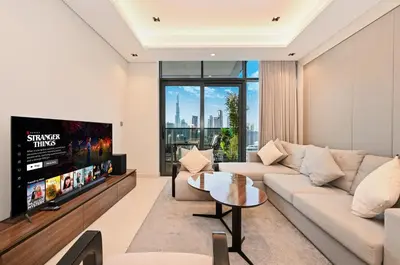 a living room with a couch and a tv at Stunning 1 Bdr Luxury with Burj Khalifa View in Dubai