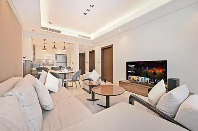 a living room with a white couch and a tv at Stunning 1 Bdr Luxury with Burj Khalifa View in Dubai