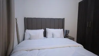 a bedroom with a large bed with white sheets and pillows at 2 Bedroom Elegant Apartment in Dubailand in Dubai