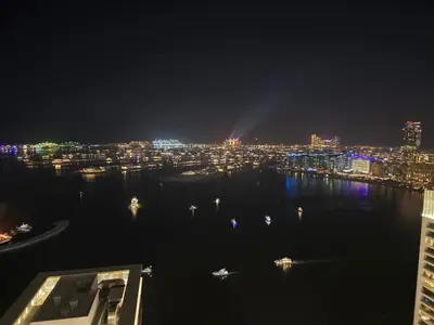 a view of a city at night with the water at Luxury Penthouse Retreat - Private Beach, Breathtaking Palm and Marina Views in Dubai
