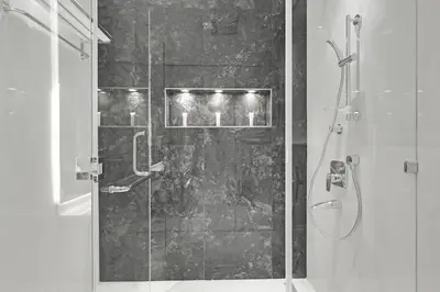 a shower with a glass door in a bathroom at Spacious 3BR , Balcony & City Views by Bhavan Vacation Homes in Dubai