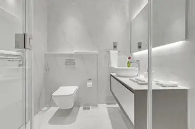 a white bathroom with a toilet and a shower at Spacious 3BR , Balcony & City Views by Bhavan Vacation Homes in Dubai