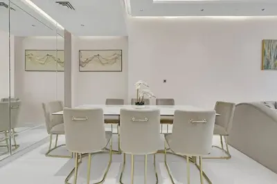 a white dining room with a table and chairs at Spacious 3BR , Balcony & City Views by Bhavan Vacation Homes in Dubai