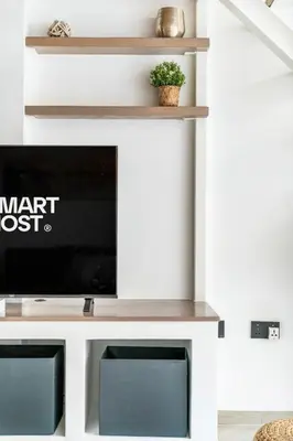 a living room with a tv on a shelf at Luxury Loft with Balcony in JVC, Oxford Terraces 2 in Dubai