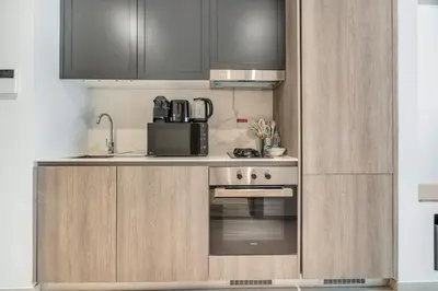a kitchen with a stove and a microwave at Luxury Loft with Balcony in JVC, Oxford Terraces 2 in Dubai