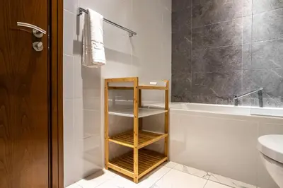 a bathroom with a wooden shelf next to a bath tub at Luxury 2Br Apt Stunning Views in Amna Tower by Simply Comfort in Dubai