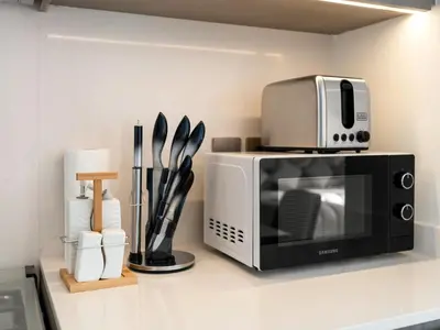 a microwave sitting on top of a counter at Grande Signature 2 Bedroom Apartments I Persian Gulf Views I Free Parking, Gym, Pool, Wi-Fi & PS5 I by Skyline Serenity in Dubai