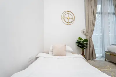 a white bedroom with a large bed and a window at GuestReady - Fabulous home with Marina Canal views in Dubai