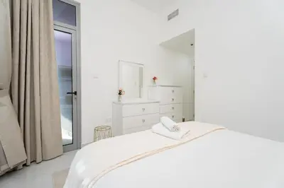 a white bedroom with a bed and a mirror at GuestReady - Fabulous home with Marina Canal views in Dubai