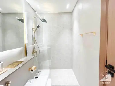 a white bathroom with a shower and a sink at Luxury & Comfort at Binghatti Amber with Balcony in Dubai
