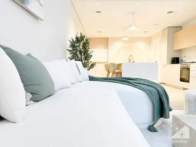 a white bed in a bedroom with a christmas tree at Sophisticated 1B Apartment in Belgravia Heights II in Dubai