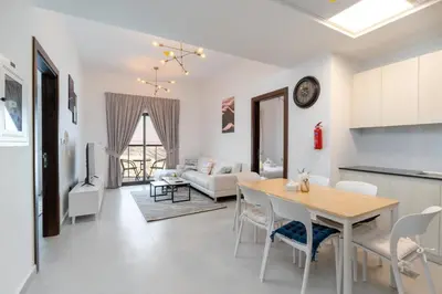 a kitchen and living room with a table and chairs at Delightful 2 Bedrooms In Jumeirah Village Circle in Dubai