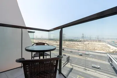 a balcony with a table and a view of a highway at Delightful 2 Bedrooms In Jumeirah Village Circle in Dubai