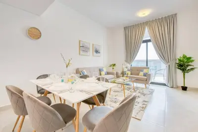 a dining room with a white table and chairs at Serene 2 Bedrooms Apartment in Dubai