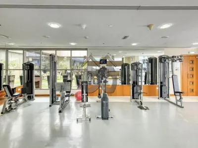 a gym with several treadmills and exercise machines at Restful studio Apartment in Dubai Sports City in Dubai