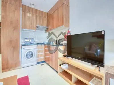 a living room with a large flat screen tv at Restful studio Apartment in Dubai Sports City in Dubai