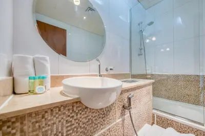a bathroom with a white sink and a mirror at Restful studio Apartment in Dubai Sports City in Dubai