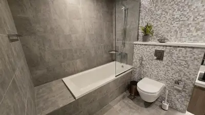 a bathroom with a tub and a toilet and a shower at Stella Maris Marine view in Dubai
