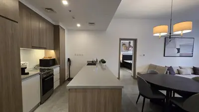 a kitchen and living room with a table and a couch at Stella Maris Marine view in Dubai