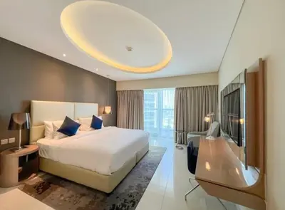 a bedroom with a large white bed and a tv at Luxury 2 Bedroom Apartment in Downtown in Dubai