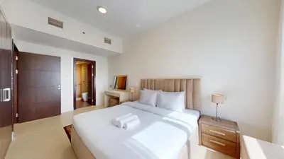 a bedroom with a large white bed with a night stand at Vacationer I Sophisticated 2 Bedroom Apartment I High Floor I Scenic Skyline Escape I Torch Tower - Marina in Dubai