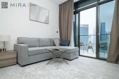 a living room with a couch and a table at Mira Holiday Homes - newly and cosy studio with balcony in Business Bay in Dubai