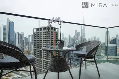 a table and chairs on a balcony with a city skyline at Mira Holiday Homes - newly and cosy studio with balcony in Business Bay in Dubai