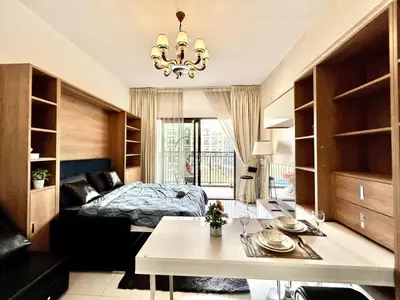 a bedroom with a bed and a table in a room at Homes2Retreat - Resort Living Close to Miracle Garden in Dubai
