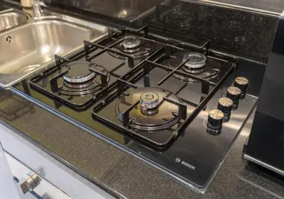 a stove top oven sitting next to a sink at Bespoke Holiday Homes - Luxurious Studio in Damac Maison Prive in Dubai