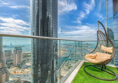 a wicker chair sitting on the balcony of a skyscraper at Pristine 2BR Apt in Dubai! JBR, Marina & Sea View in Dubai