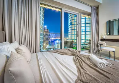 a bedroom with a large bed and a large window at Pristine 2BR Apt in Dubai! JBR, Marina & Sea View in Dubai