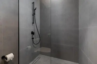 a bathroom with a shower with a roll of toilet paper at Waves - Elegant Waterfront Living in Dubai's Business Bay in Dubai