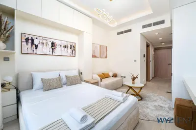 a bedroom with a large bed and a living room at Winter Bliss Studio Azizi Riviera 9 Pool View in Dubai