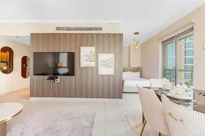 a living room with a television and a couch at Durrani Homes - Modern Living 3br with Burj Khalifa and Fountain View - third room without partition in Dubai