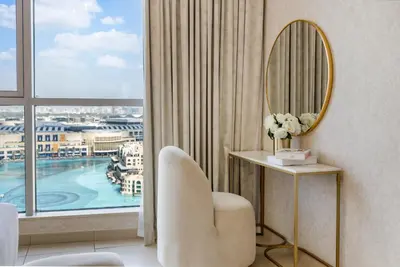 a room with a mirror and a chair and a window at Durrani Homes - Modern Living 3br with Burj Khalifa and Fountain View - third room without partition in Dubai