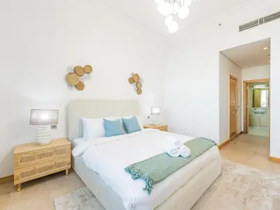 a bedroom with a large white bed with blue pillows at Beachfront Sea View 1BR-Jash Falqa- Palm Jumeirah in Dubai