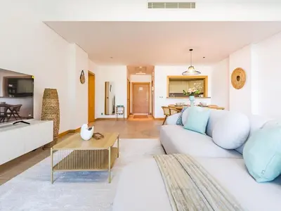 a living room with a white couch and a table at Beachfront Sea View 1BR-Jash Falqa- Palm Jumeirah in Dubai