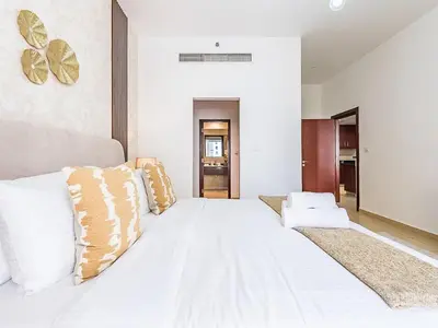 a large white bed with pillows on top of it at The Cozy Cove 1BR at Rimal 4,JBR in Dubai