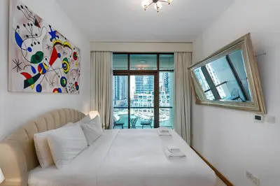 a bedroom with a white bed with a large window at Iris Blue, Dubai Marina - Mint Stay in Dubai