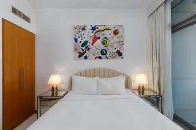 a bedroom with a white bed and two lamps at Iris Blue, Dubai Marina - Mint Stay in Dubai