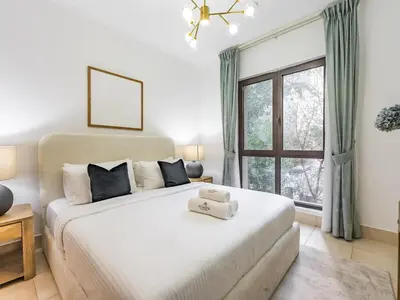 a bedroom with a large white bed and a window at Cozy 1BR- Yansoon 4- Heart of Downtown Dubai in Dubai