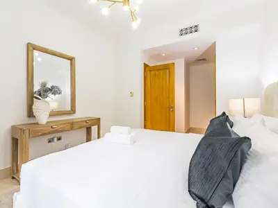 a bedroom with a white bed and a mirror at Cozy 1BR- Yansoon 4- Heart of Downtown Dubai in Dubai