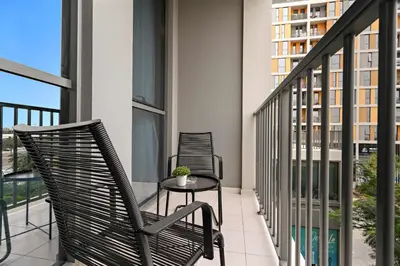 two chairs and a table on a balcony at Silkhaus Signature 1BR in Afnan at Production City in Dubai