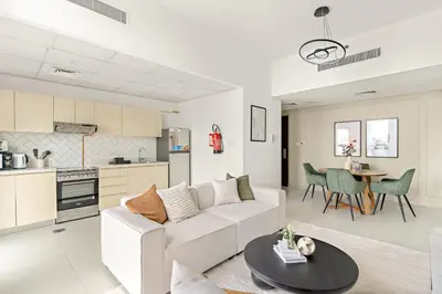 a living room with a white couch and a table at Silkhaus Signature 1BR in Afnan at Production City in Dubai