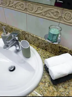 a bathroom sink with a towel and a glass of green liquid at Luxury 2-bedroom in Dubai Marina with Sea View in Dubai