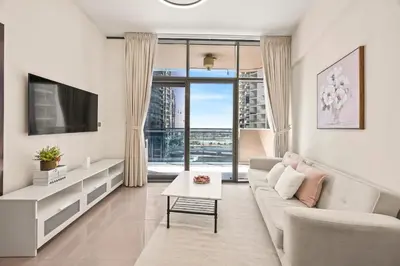 a living room with a couch and a tv at C&L Homes Dubai Canal in Dubai