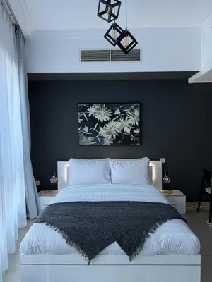 a bedroom with a large bed with a blue wall at Modern Studio in Dubai Marina, JBR in Dubai
